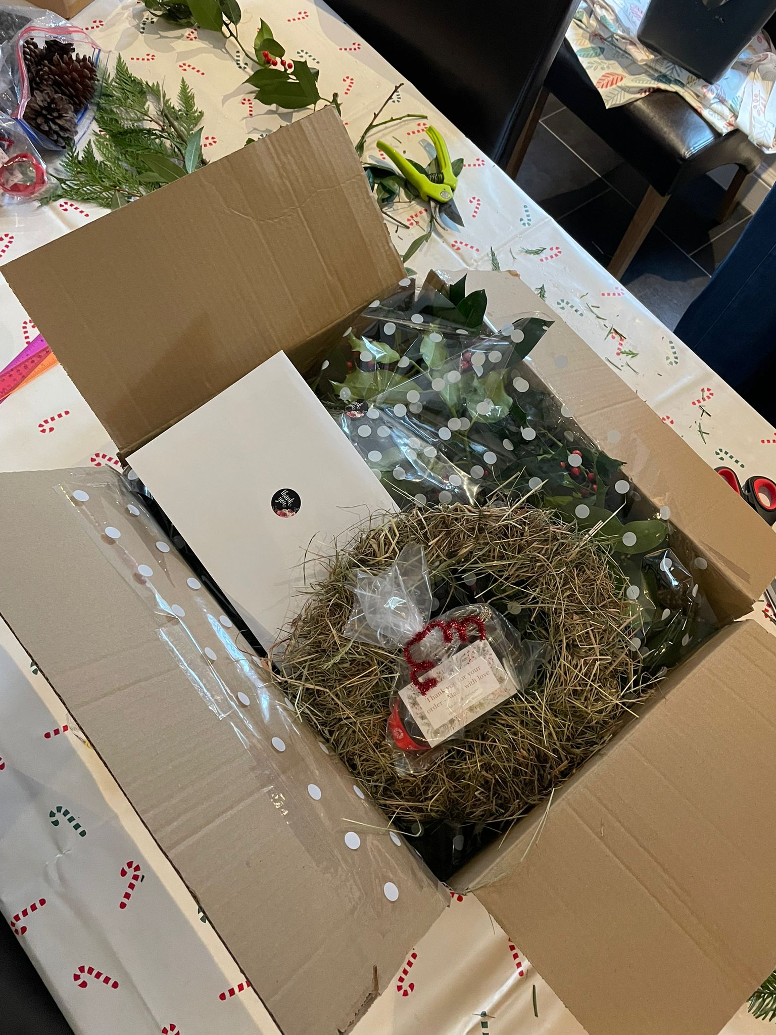 DIY Christmas wreath-making supplies including festive ribbon, dried fruit, cinnamon and pine cones