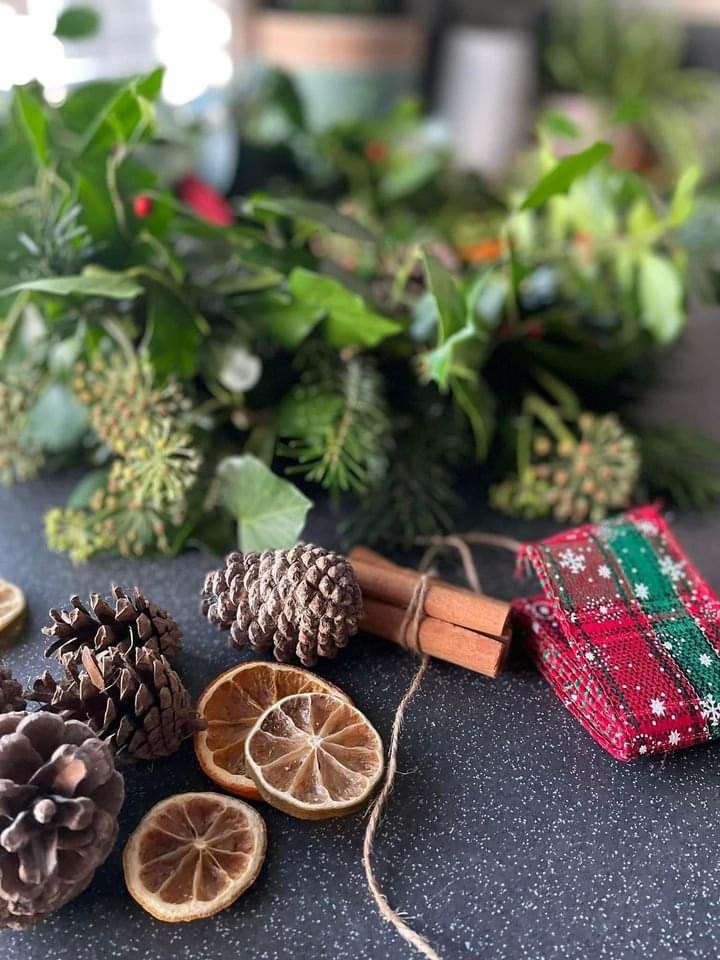 Festive wreath decorations including pine cones, dried citrus, cinnamon and ribbon